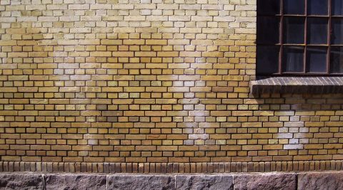 Facade af teglsten med tegn på opstigende grundfugt