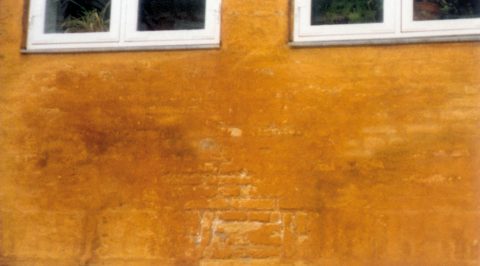 Nedbrudt kalk og puds på  fugtbelastet facade