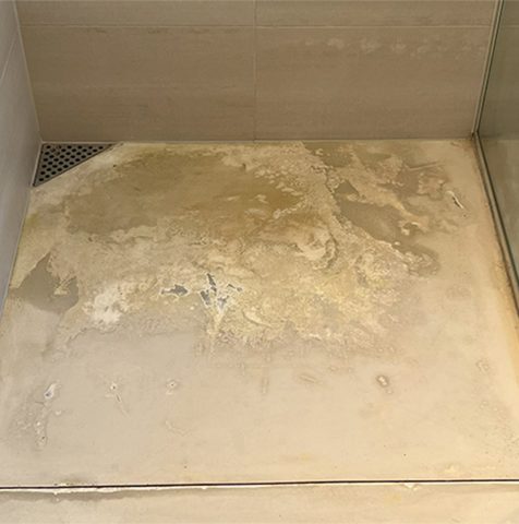 Gulv i bruseniche med microcementbelægning, som er ved at gå i opløsning. 